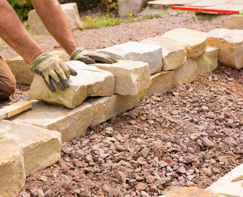 Side View Of A Landscaper Installing Rocks